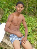 Latino boy strip teasing in an old tree trunk